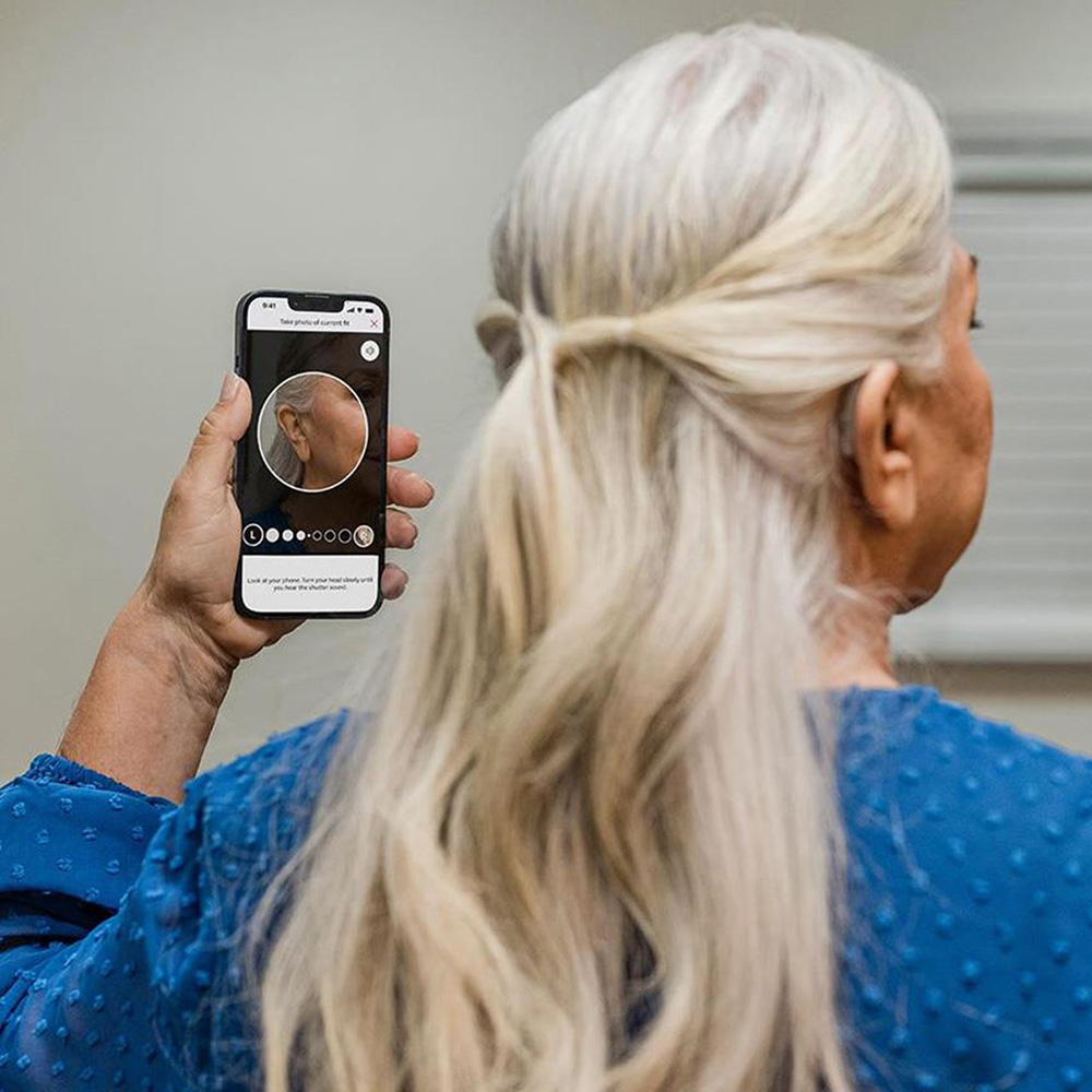 a person wearing Beltone hearing aids checking their fit with the Beltone HearMax™ app